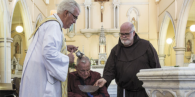 Blessed day: Fr Peter Dillon baptises Bill Hayden at St Mary’s Church, Ipswich, assisted by Fr Stephen Bliss. Photo: Alan Edecomb.