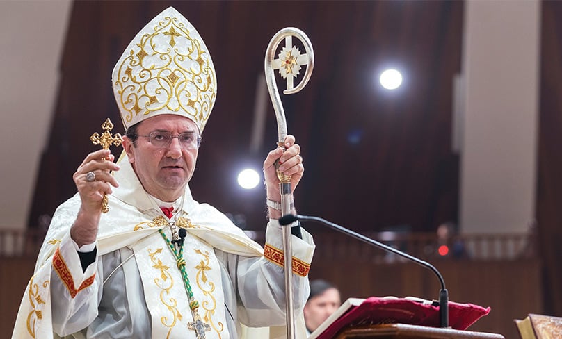 Bishop Antoine-Charbel Tarabay, head of the Maronite Church in Australia, holds a crucifix during Saturday’s Mass. Photo: Patrick J Lee